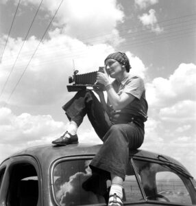 Portrait of Photographer Dorothea Lange on top of a car